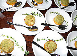 Drei Reihen kleiner wei&szlig;er Teller mit Zucchini-Karotten-Flan