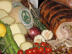 Detail aus einem rustikalen Buffet: Schinken, verschiedene K&auml;se, Tomaten, Zwiebeln, Knoblauch